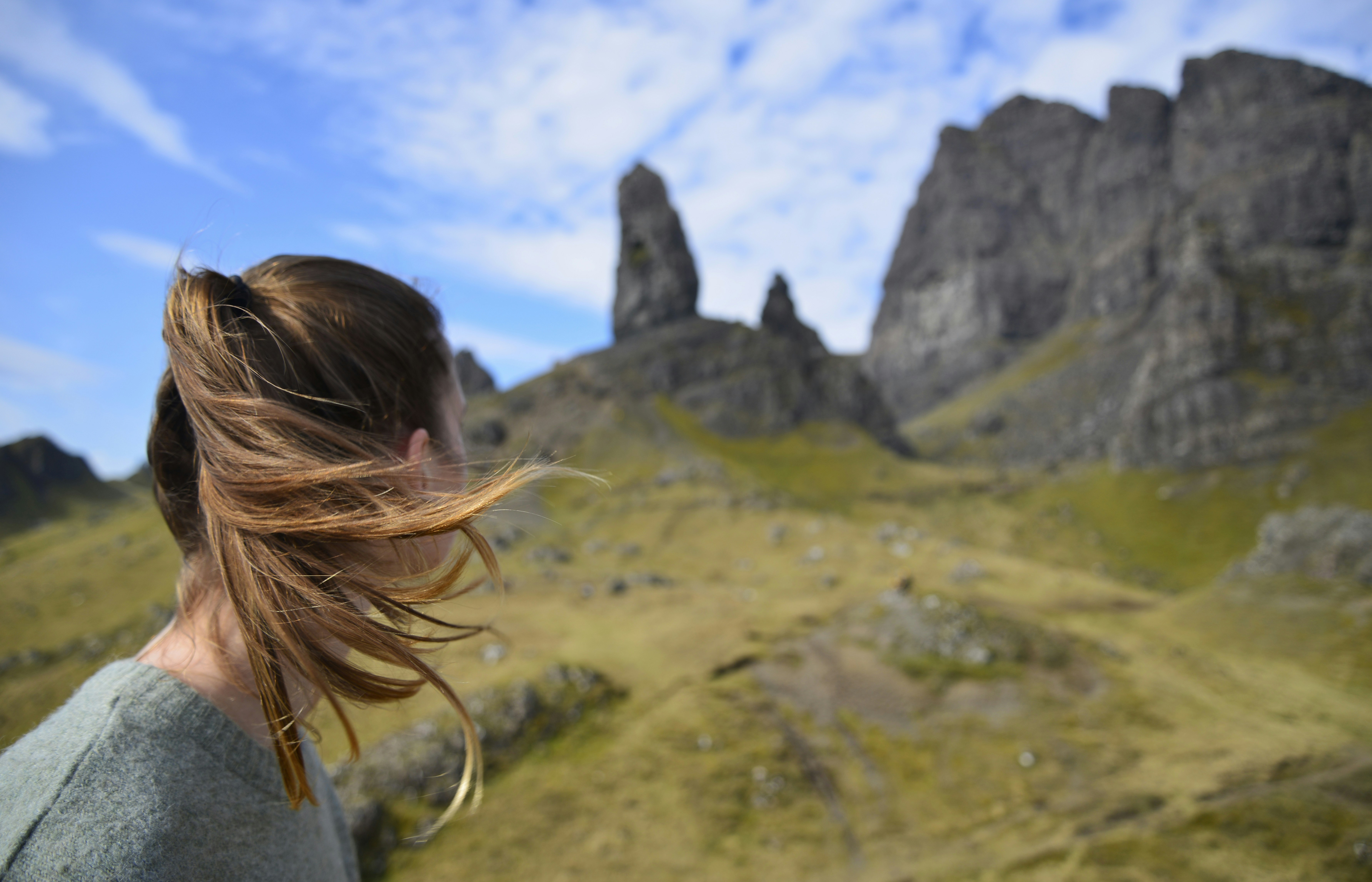 Young woman looks at Old Man of Storr.