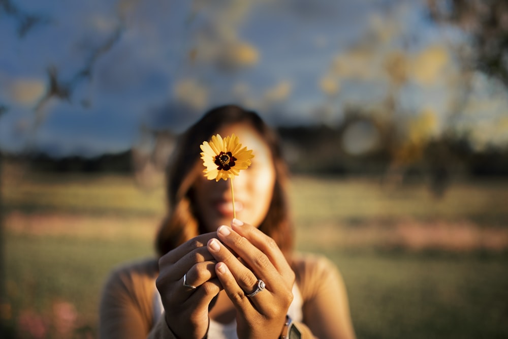 woman holding yellow sunflower