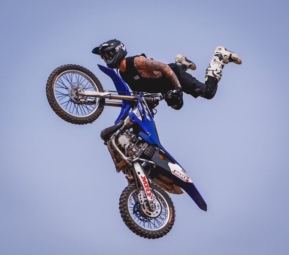 rider with blue dirt bike soaring on air