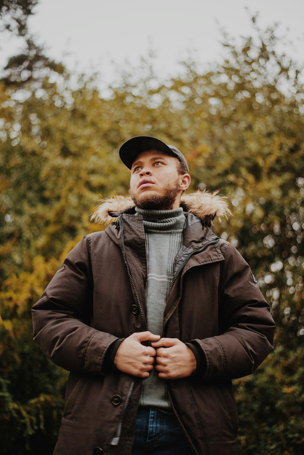 man in brown parka jacket standing