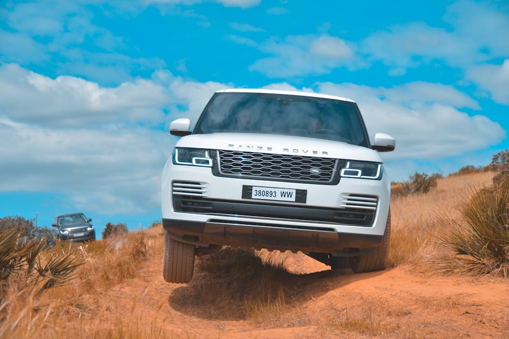 white Land Rover Range Rover on brown field