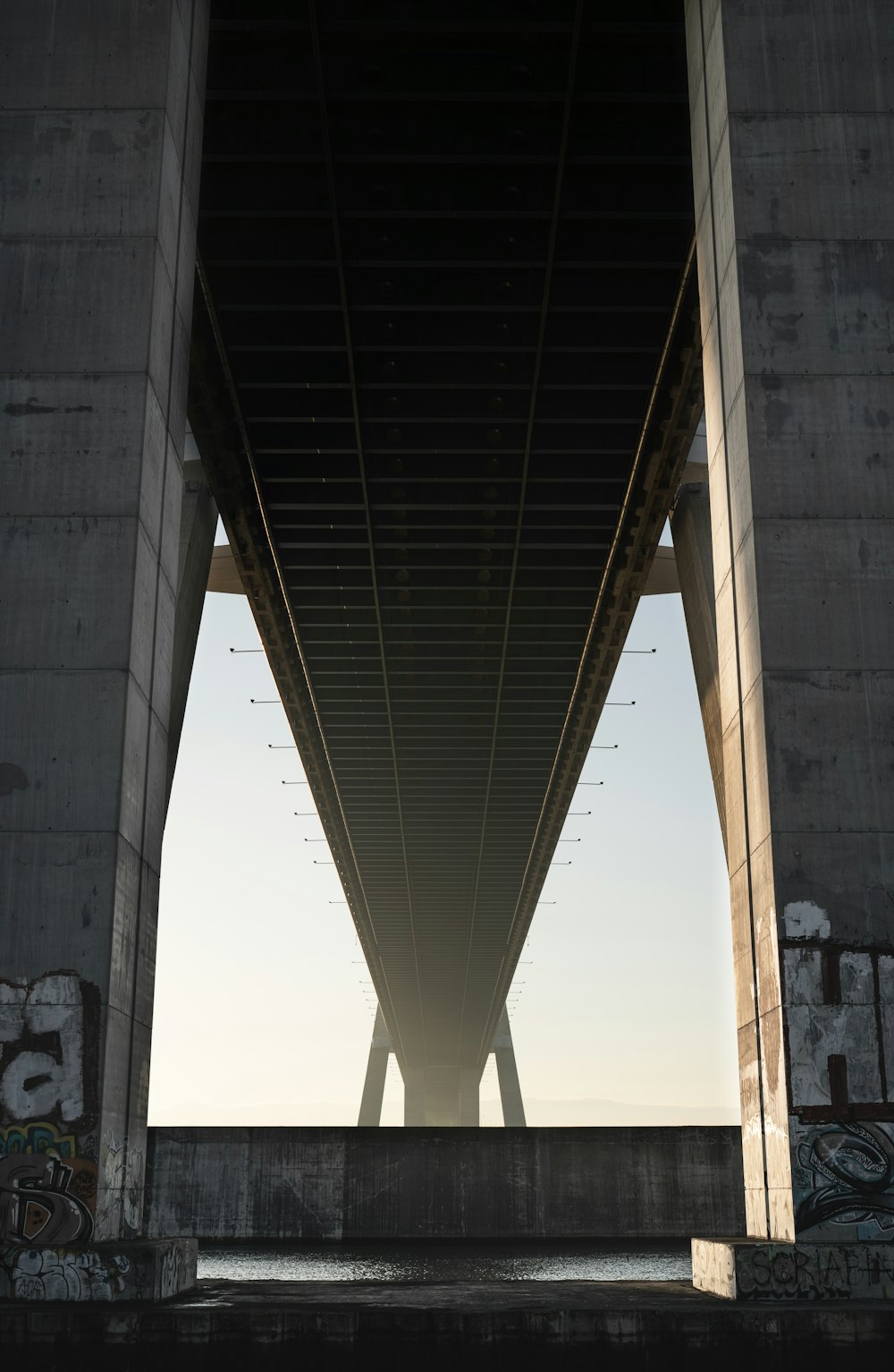 a view of the underside of a bridge over water