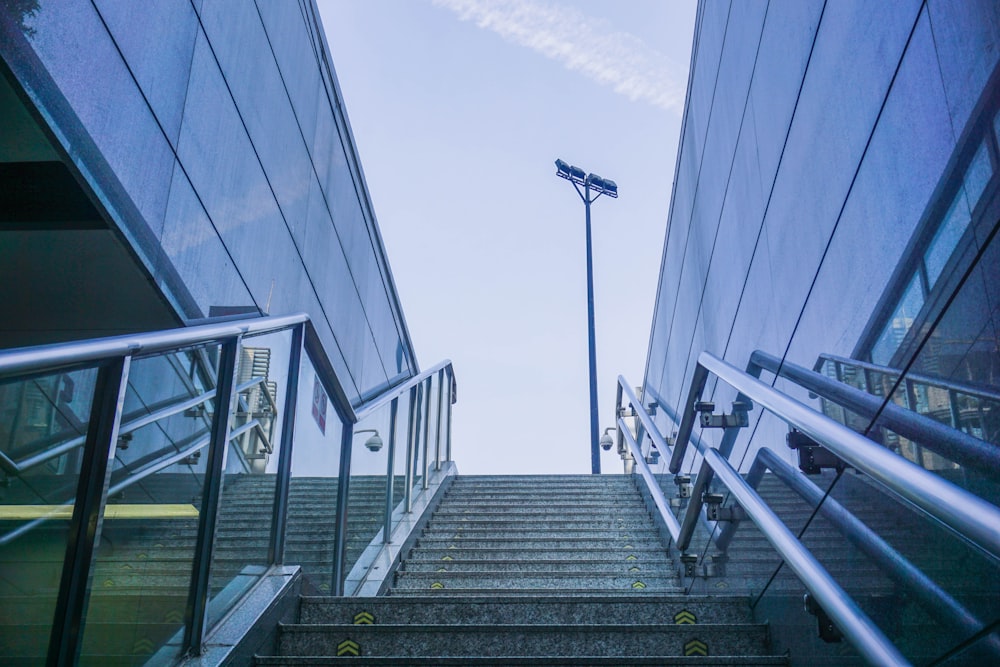 stairs with metal railings near glass building during daytime