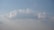 A large, fluffy white cloud floating in a clear blue sky with a soft gradient towards the horizon.