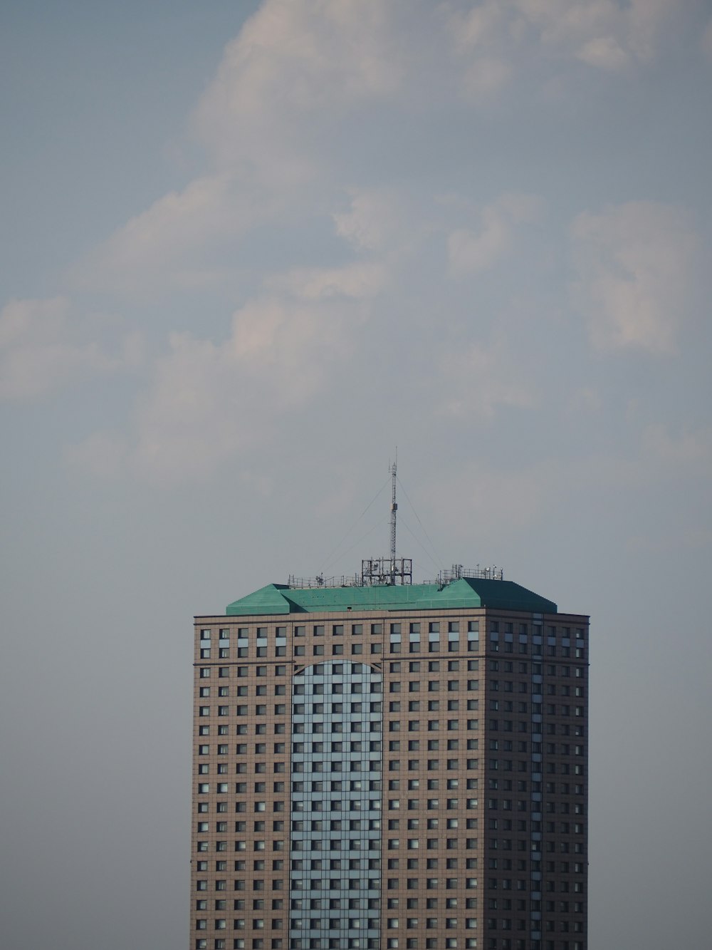 a very tall building with a green roof