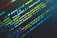 Lines of colorful code are displayed on a dark background, showcasing various programming functions and syntax. The text is highlighted in different colors to indicate different parts of the code, which includes strings, variables, and functions.