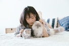 woman lying beside two kittens