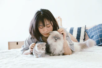 woman lying beside two kittens