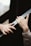 Two hands are reaching towards each other with an emotional and gentle gesture. The surroundings are blurred, focusing attention on the hands.