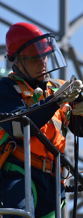 shallow focus photo of man fixing steel cable