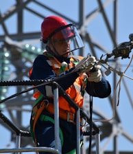 shallow focus photo of man fixing steel cable