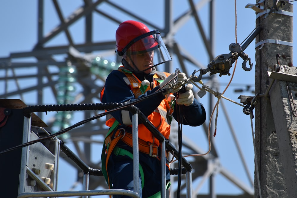 shallow focus photo of man fixing steel cable