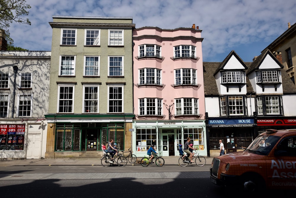 people riding bike in front of building during daytime