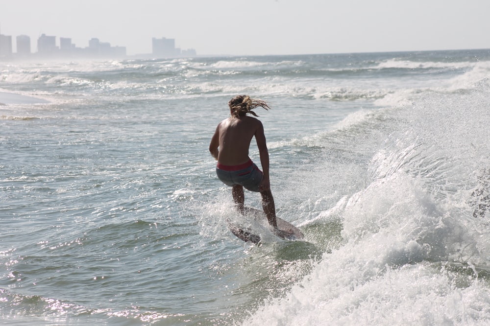 topless man riding surfboard