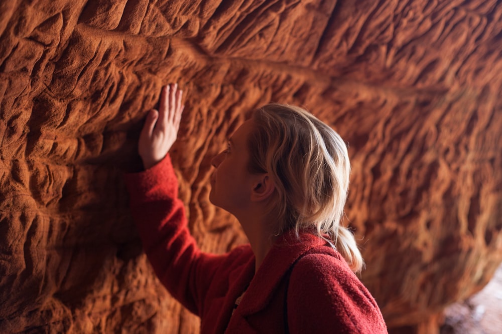 woman standing in front of brown rock formation