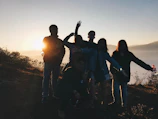 Sunset view of a group hiking together on a mountain trail.