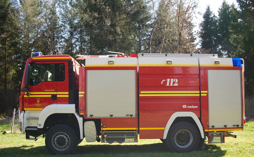 red firetruck near green trees during daytime