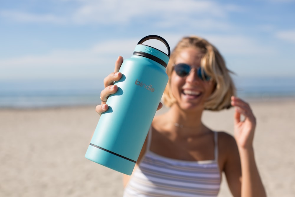 Mujer sosteniendo vaso azul