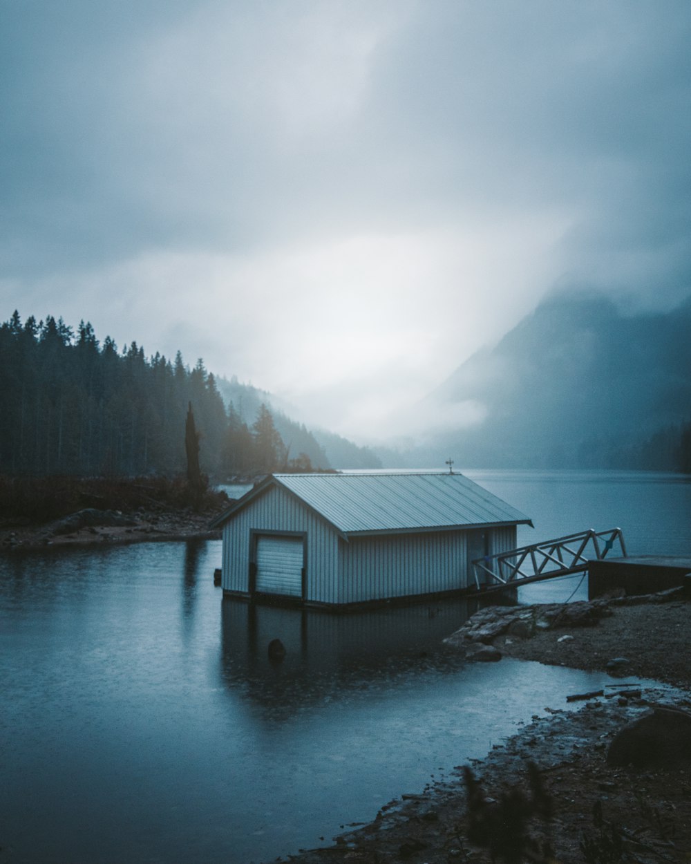 Maison en bois blanc près du plan d’eau pendant la journée