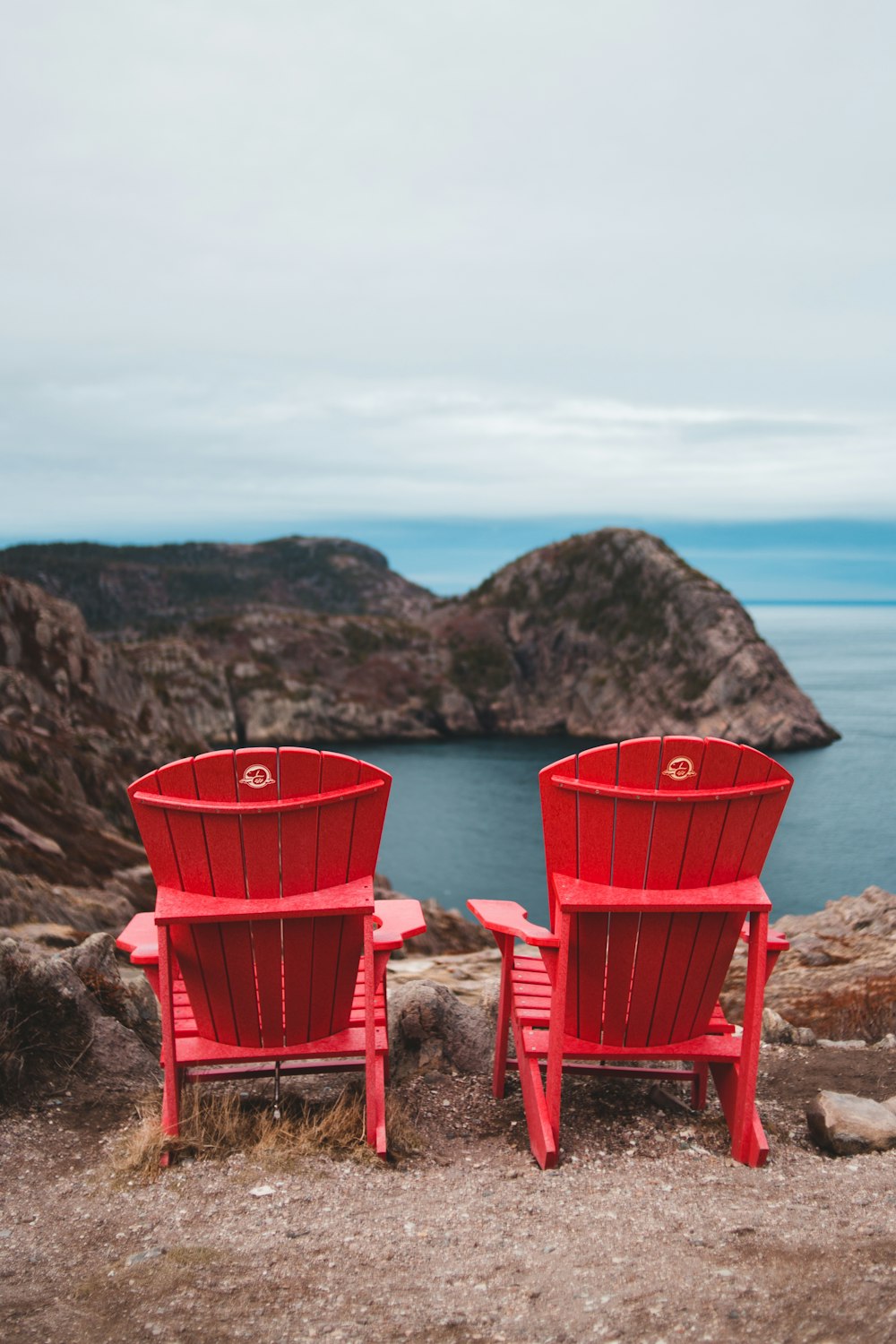 two red wooden adirondack chairs