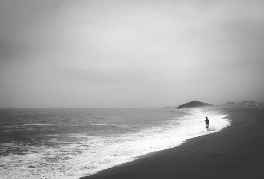 a person standing on a beach next to the ocean