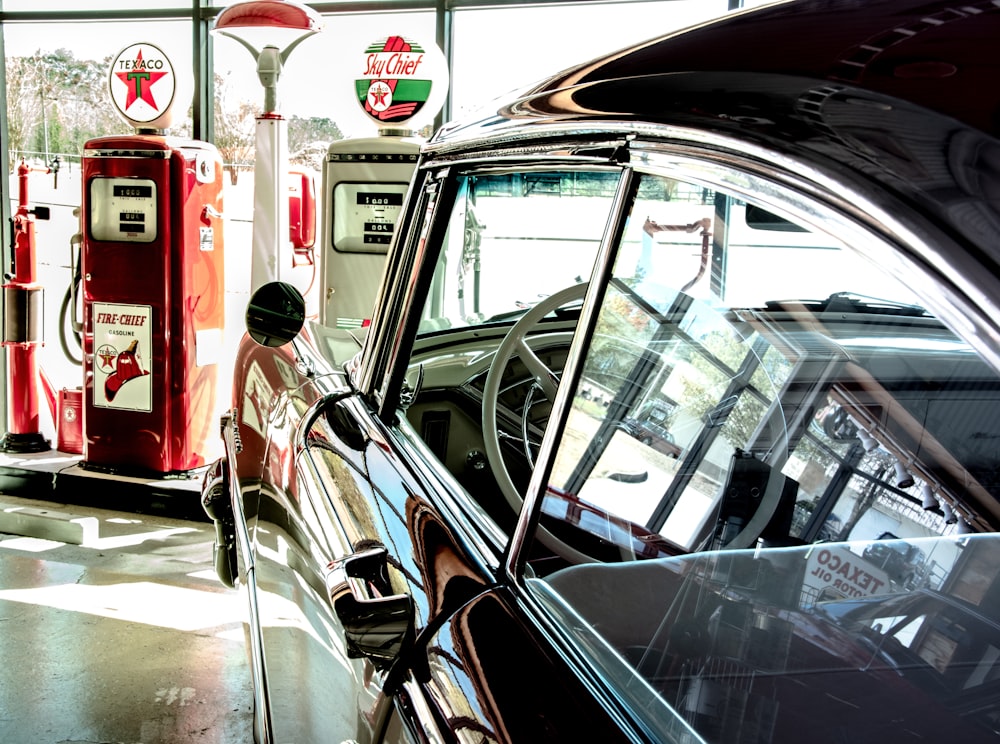 vintage black car parked near gas station