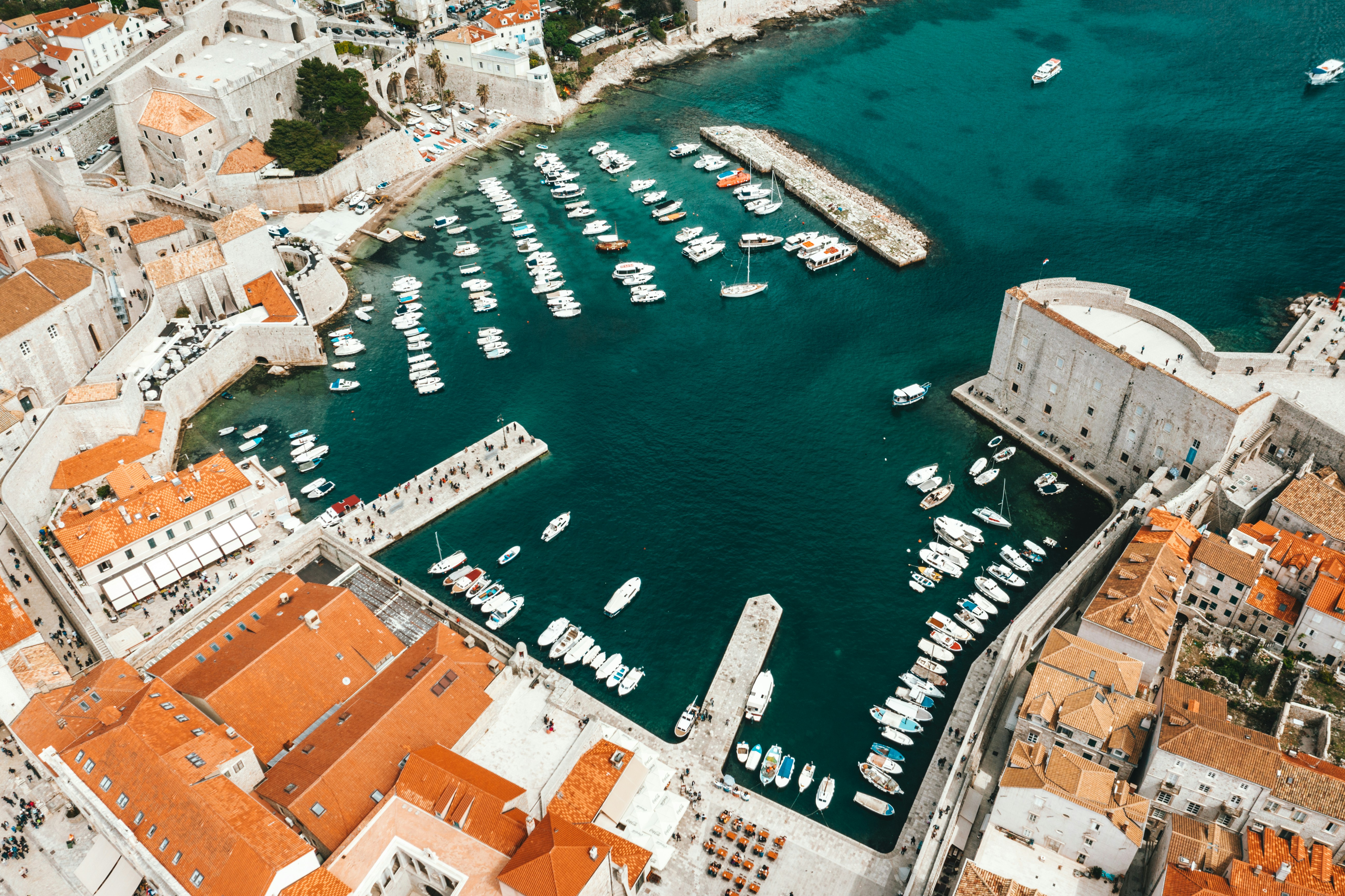 Aerial view of colorful fishing boats on turquoise water in Mediterranean harbor