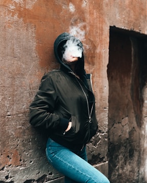 woman smoking while leaning on the wall