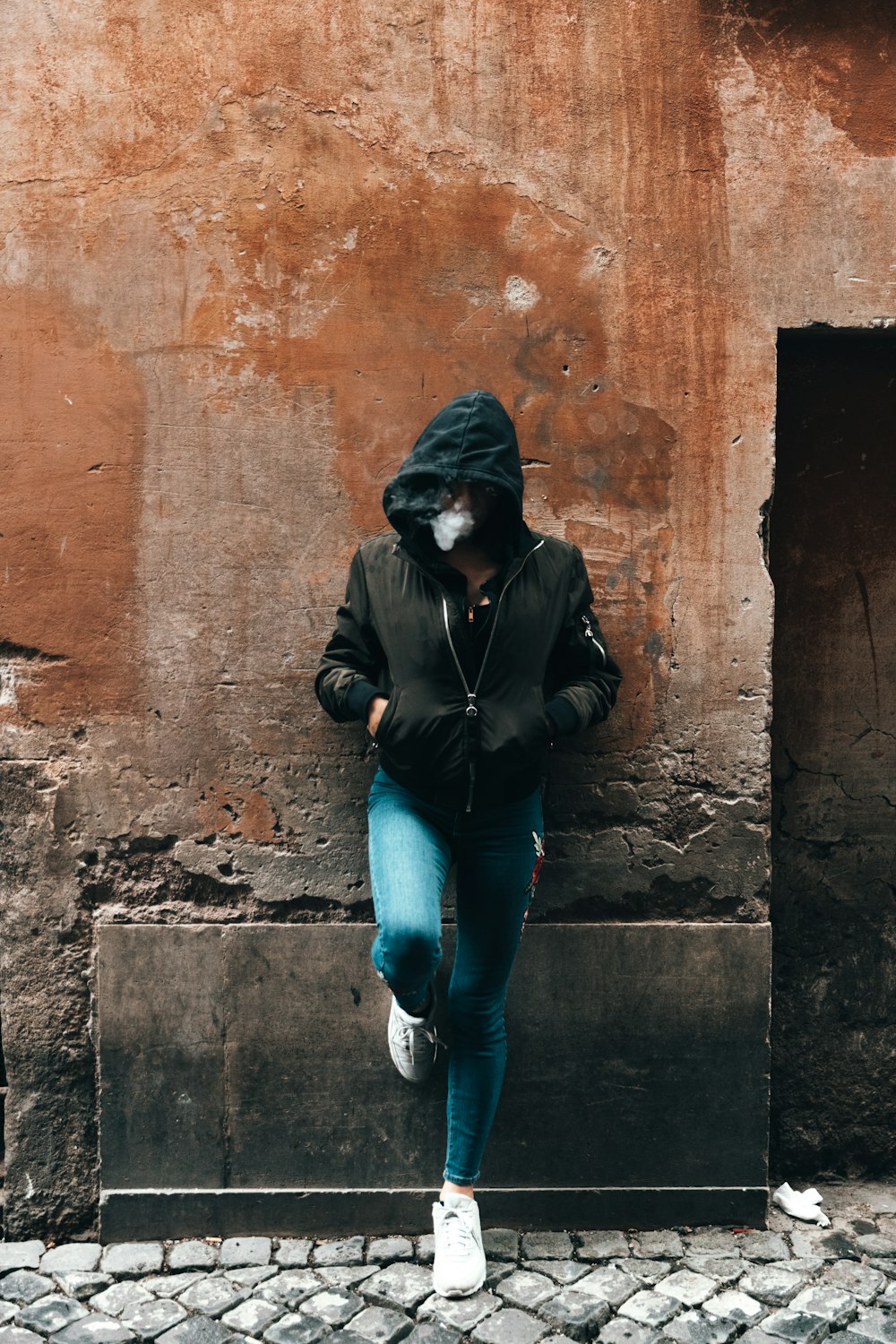 man leaning on red wall