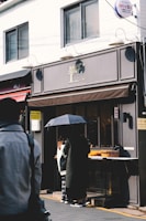 A modern storefront with a stylish canopy providing shade.