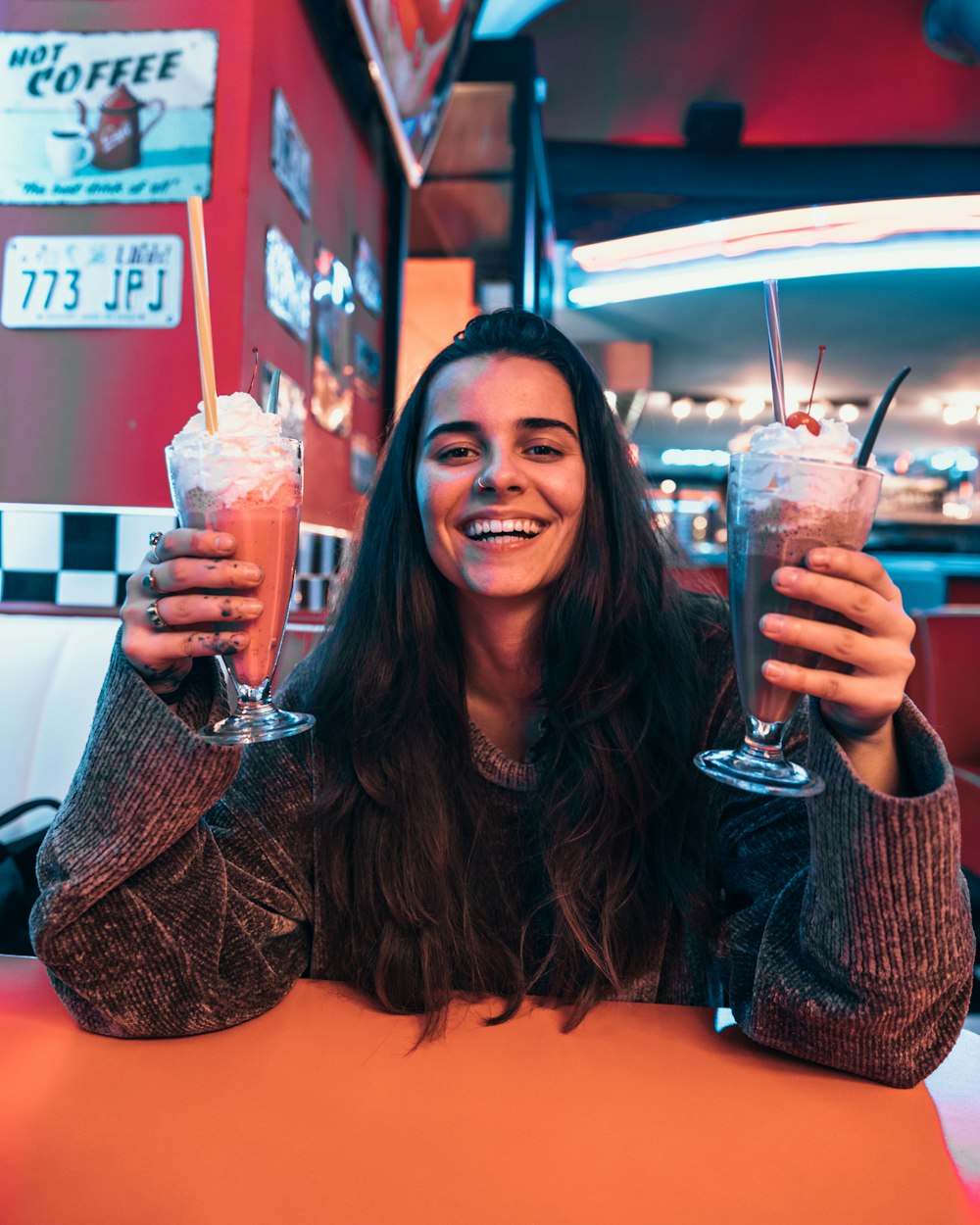 woman wearing sweater holding shake glasses