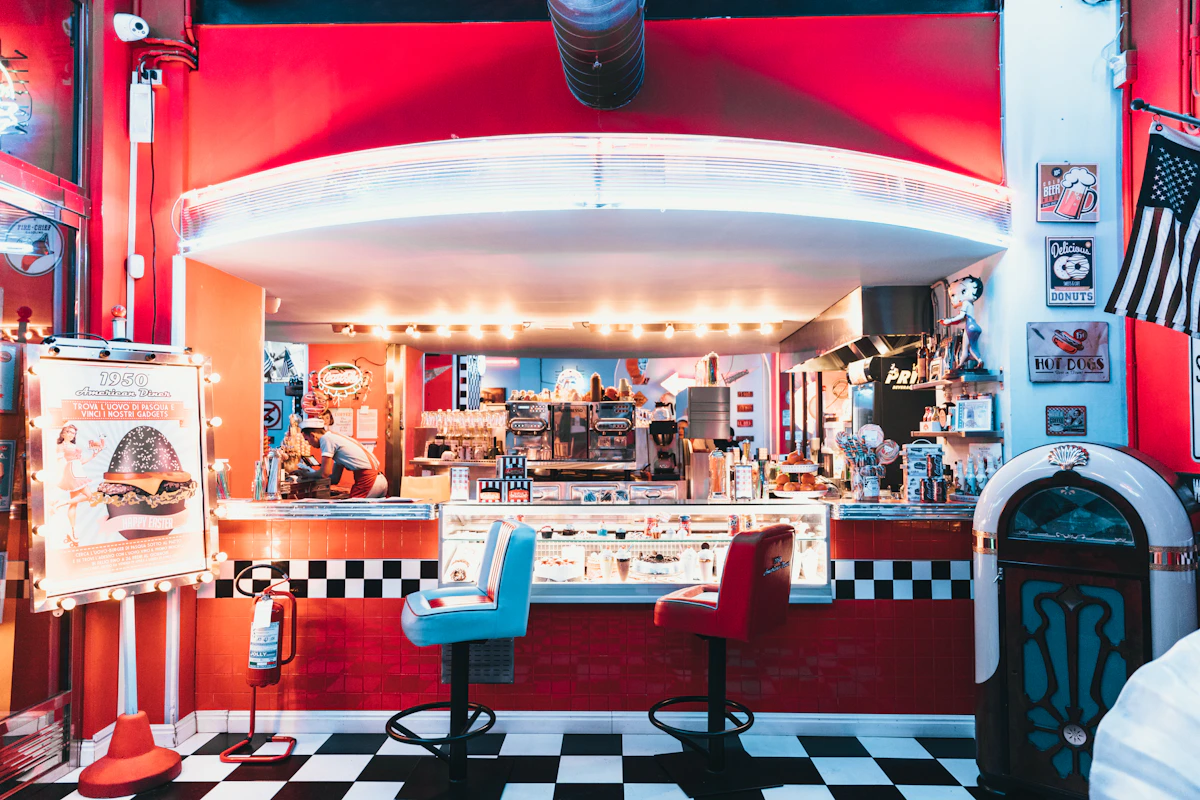 An empty retro diner lit by neon, analogous to silent churn, where the empty booths record that customers left but never record why, so the remaining feedback comes only from the people who stayed