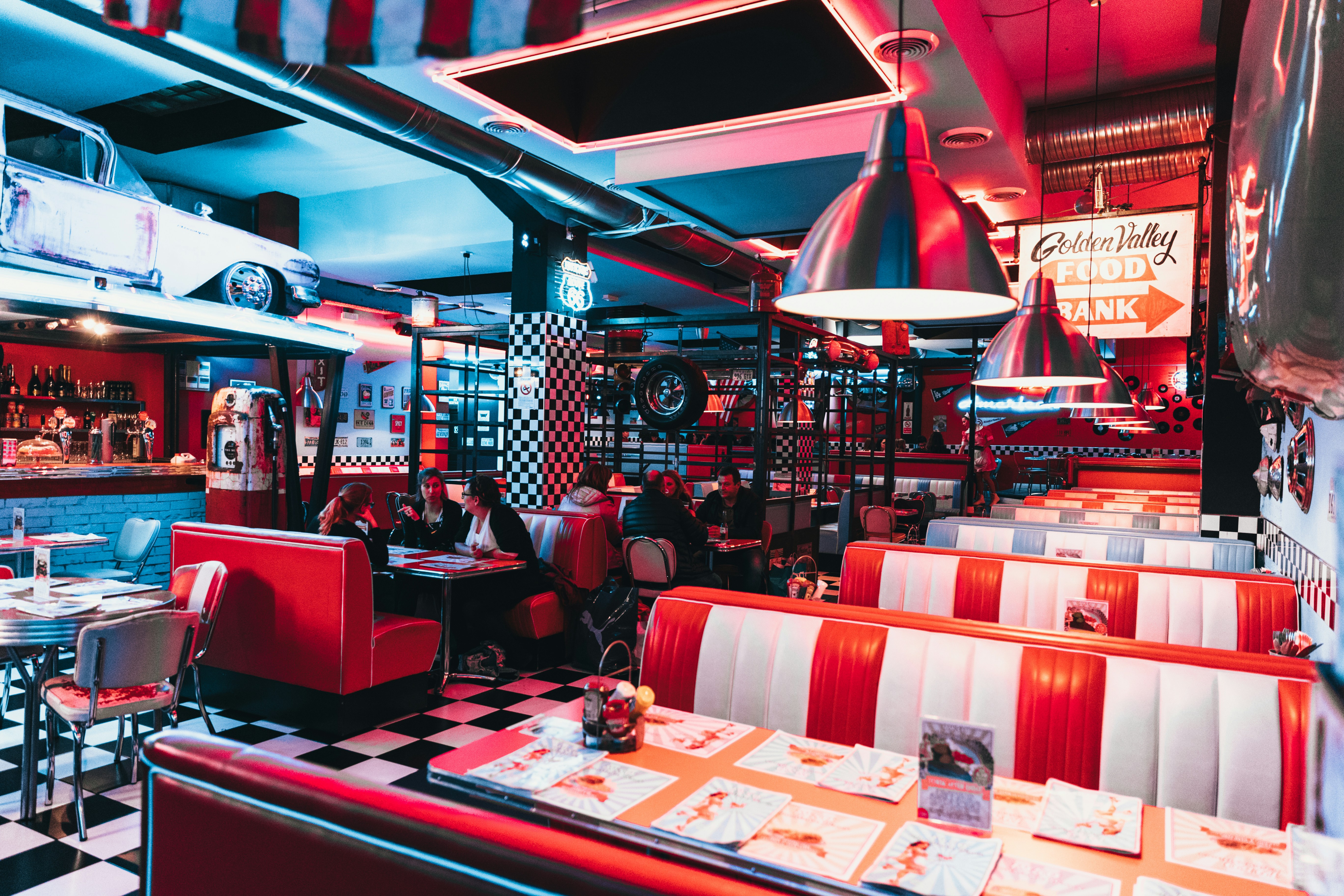a restaurant with red and white checkered tables and booths, 