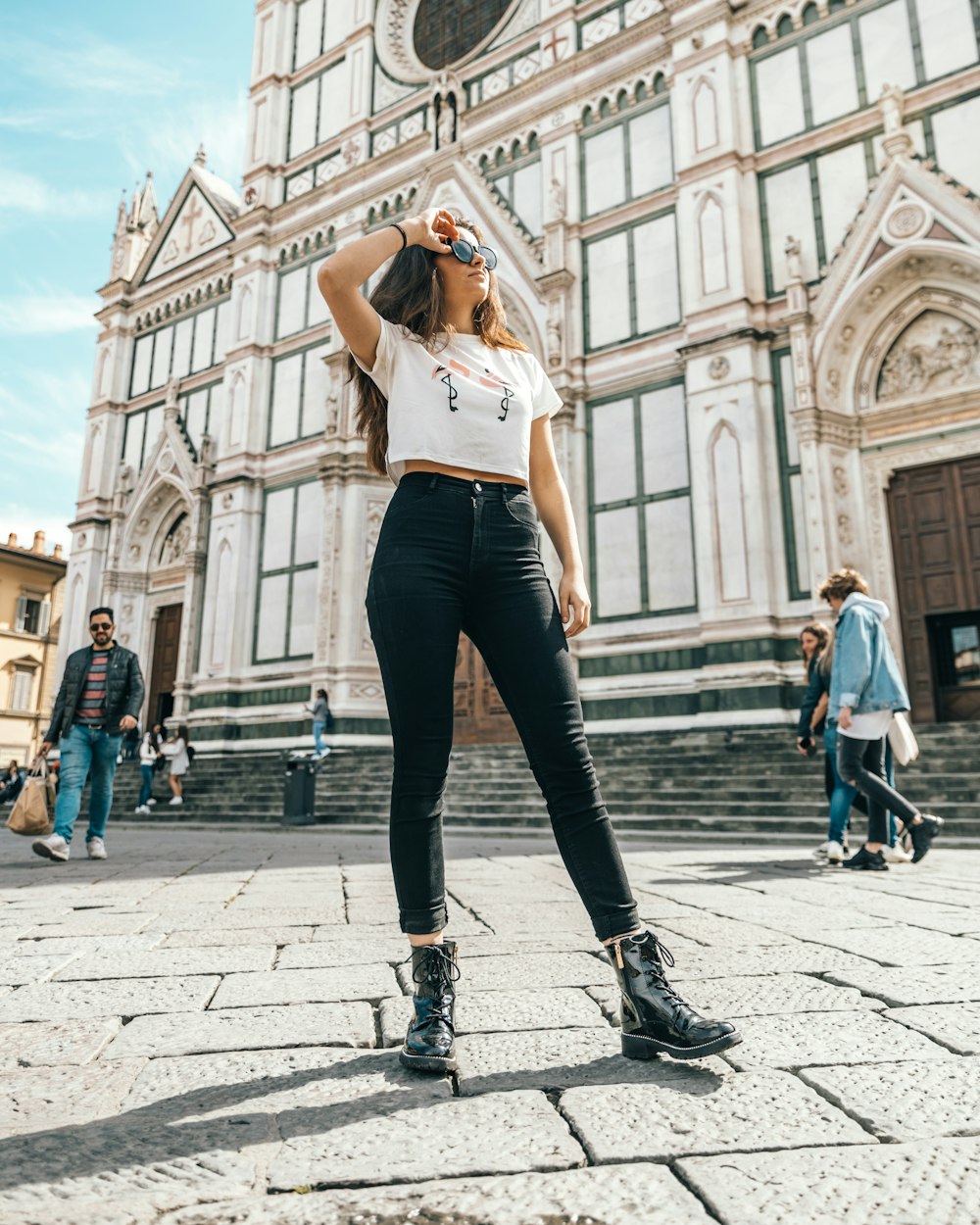 woman wearing white t-shirt standing near church