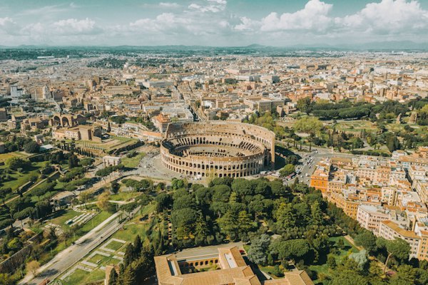 An aerial view of the Colosseum and surrounding city streets in Rome, Italy