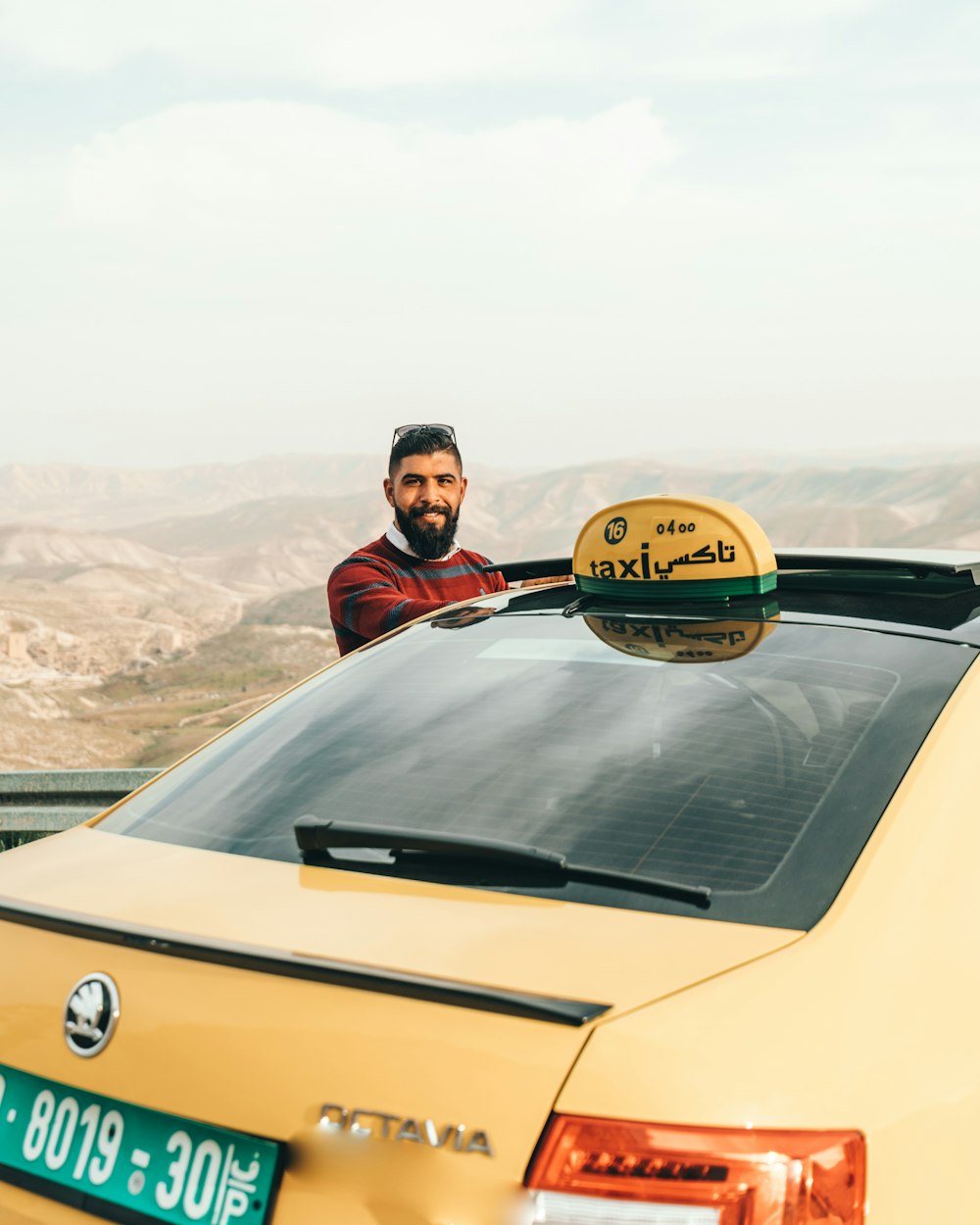 man standing beside yellow Skoda Octavia vehicle