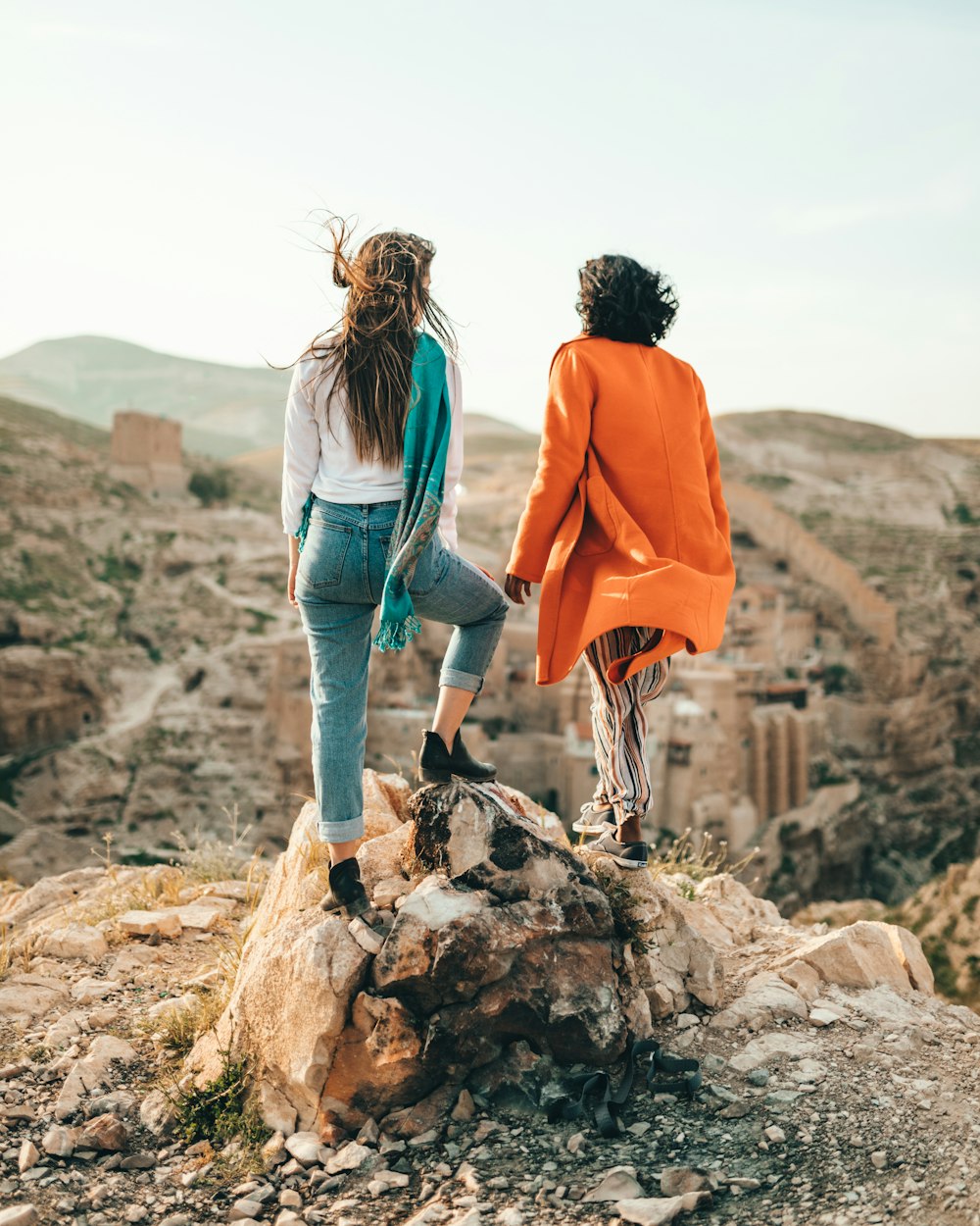 two people standing on rock formation during daytime