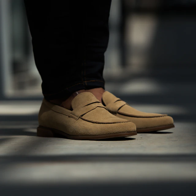 A man wearing brown leather loafers