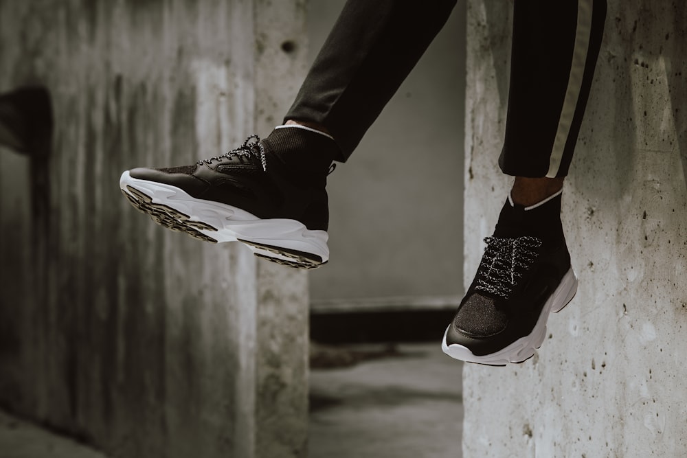 sitting person wearing black-and-white running shoes