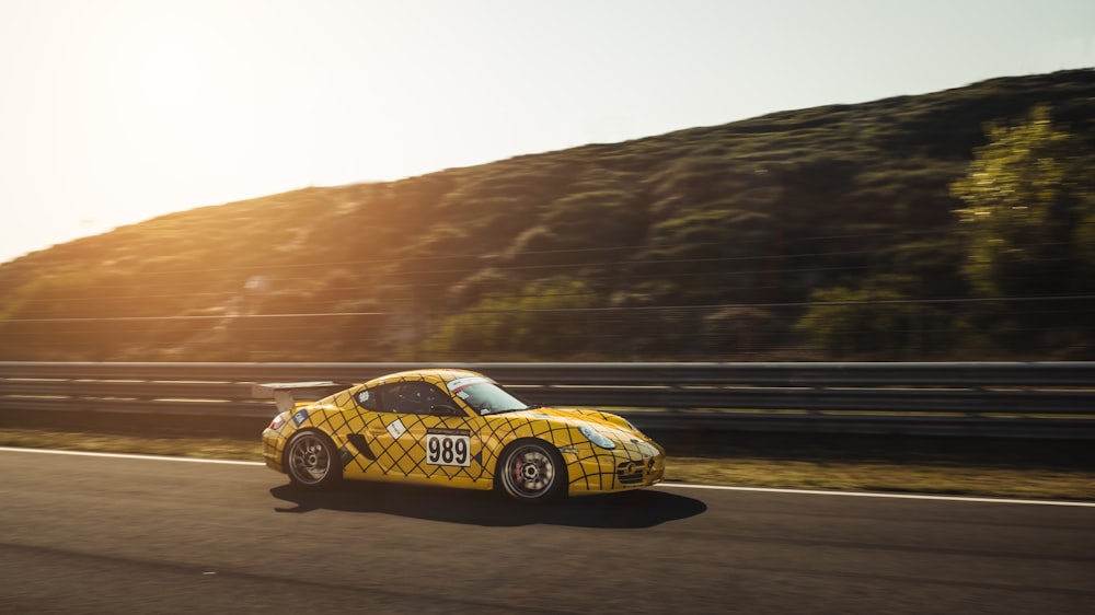 Foto panoramica dell'auto gialla che corre sulla strada