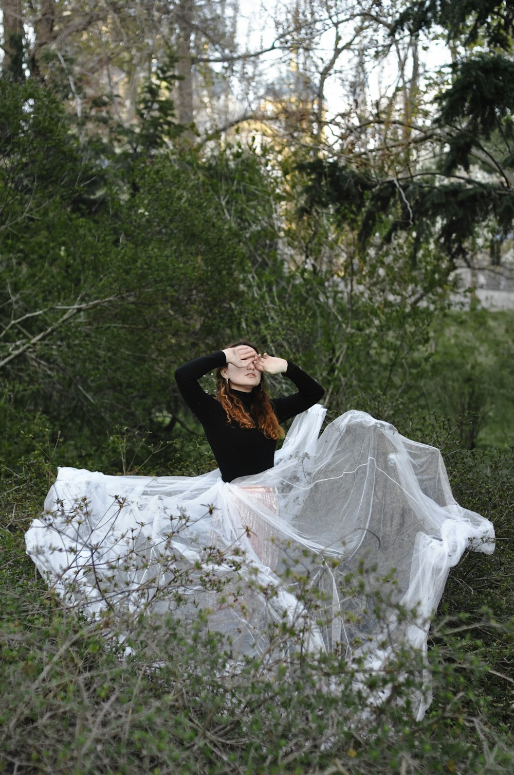 woman in white and black dress sitting on forest