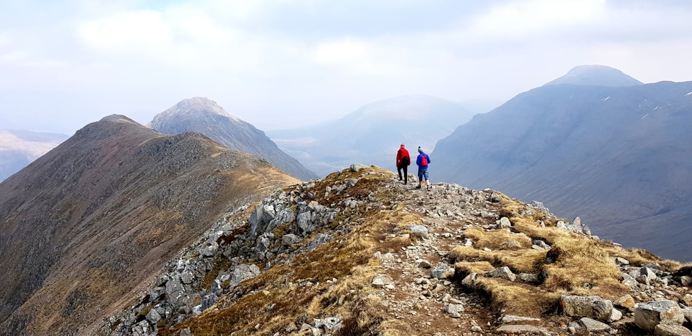 two person walking on top of mountain