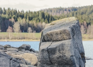 a large rock sitting on top of a sandy beach