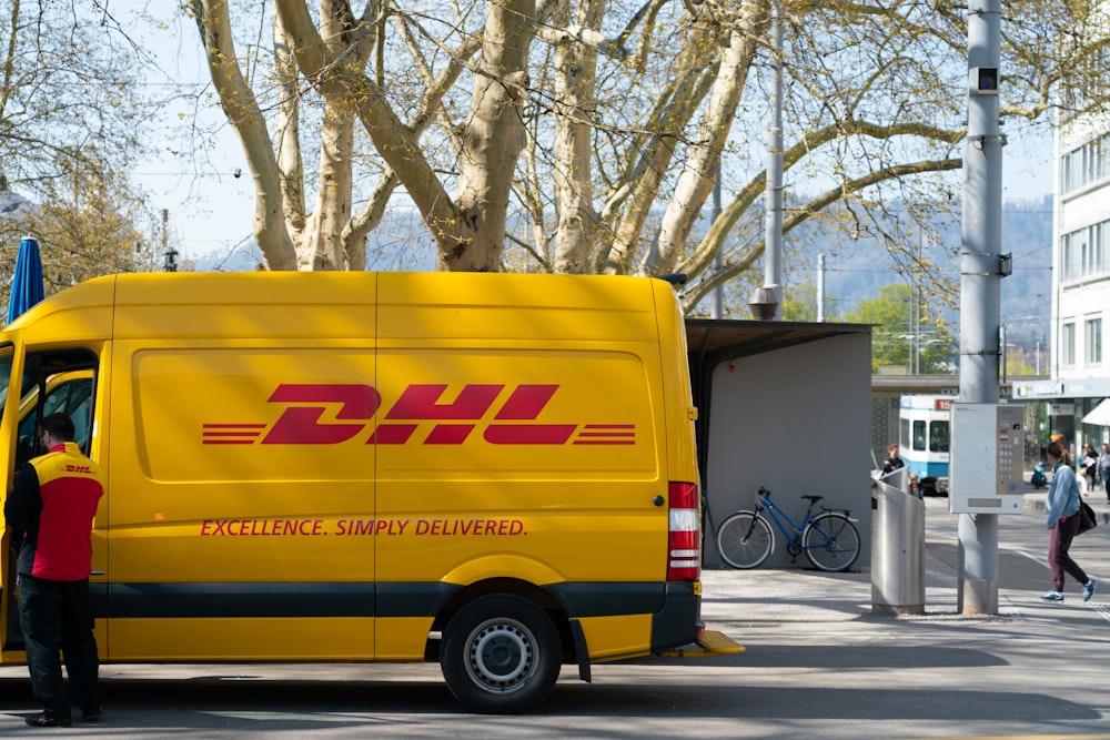 hombre parado frente a la puerta del camión de DHL