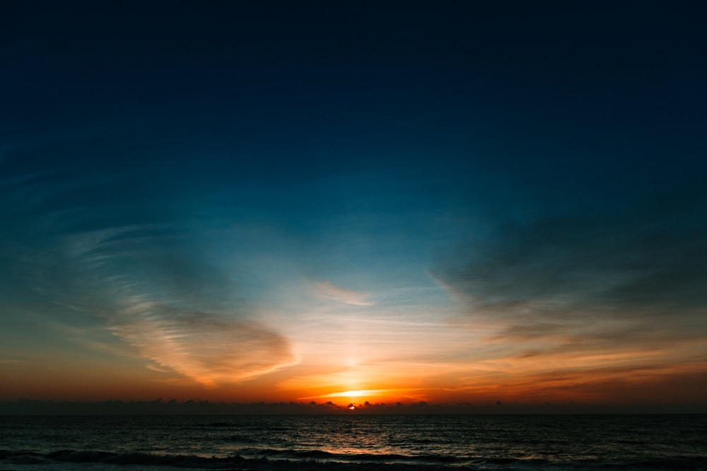 body of water under blue sky