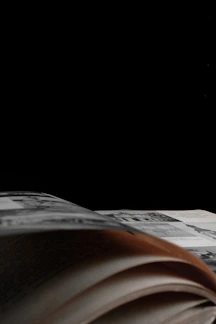 Close-up shot of a sleek black e-book cover with gold accents glowing subtly in dark ambiance.