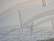 Curved steel beams intersect and support a translucent, light-colored canopy, creating a pattern of repetitive arches. The structure appears modern and industrial, with a minimalist aesthetic that emphasizes geometry and symmetry.
