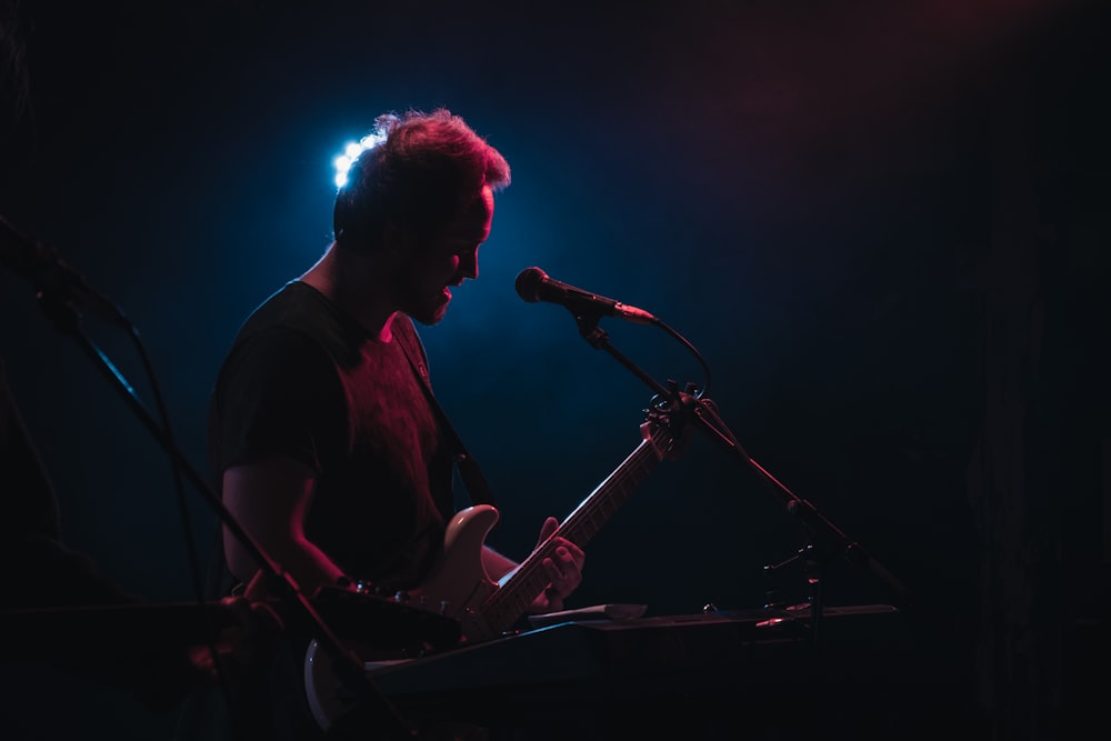 man playing electric guitar performing on stage