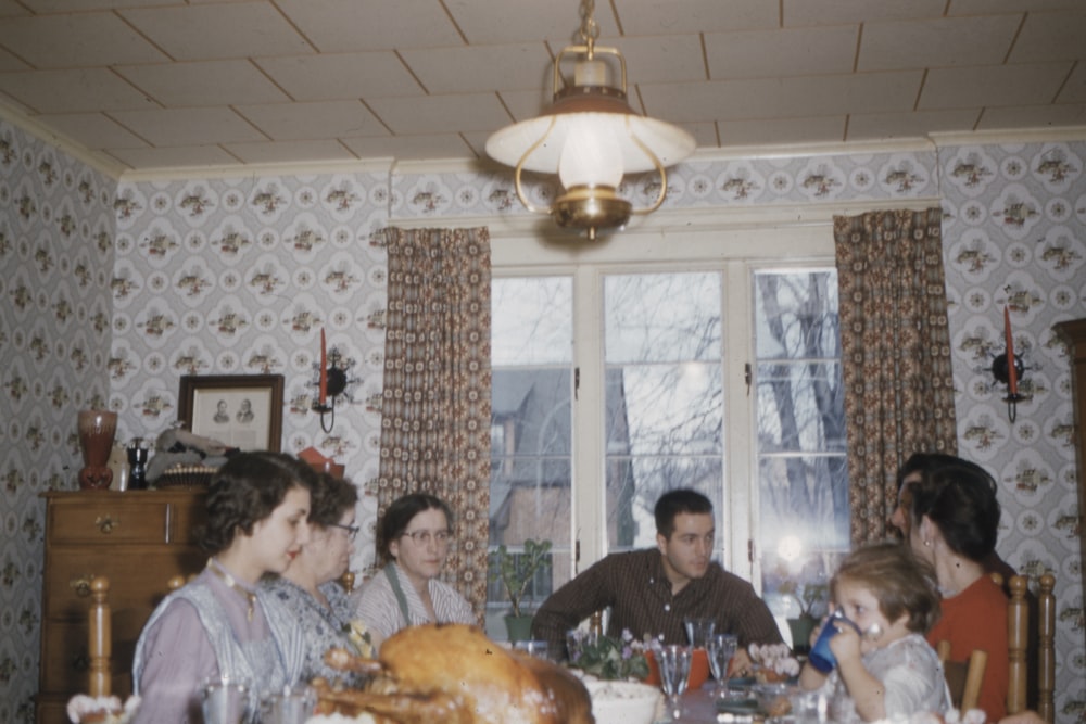 people sitting on dining chair in front of table