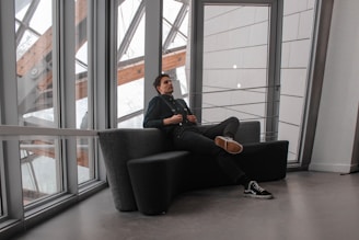 An elegant business traveler reviewing documents in a minimalist lounge with black and green accents.